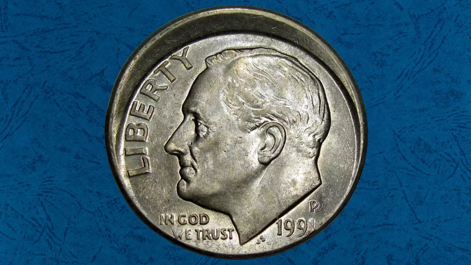 1991 Roosevelt dime off-center strike error showing misaligned design with blank planchet visible